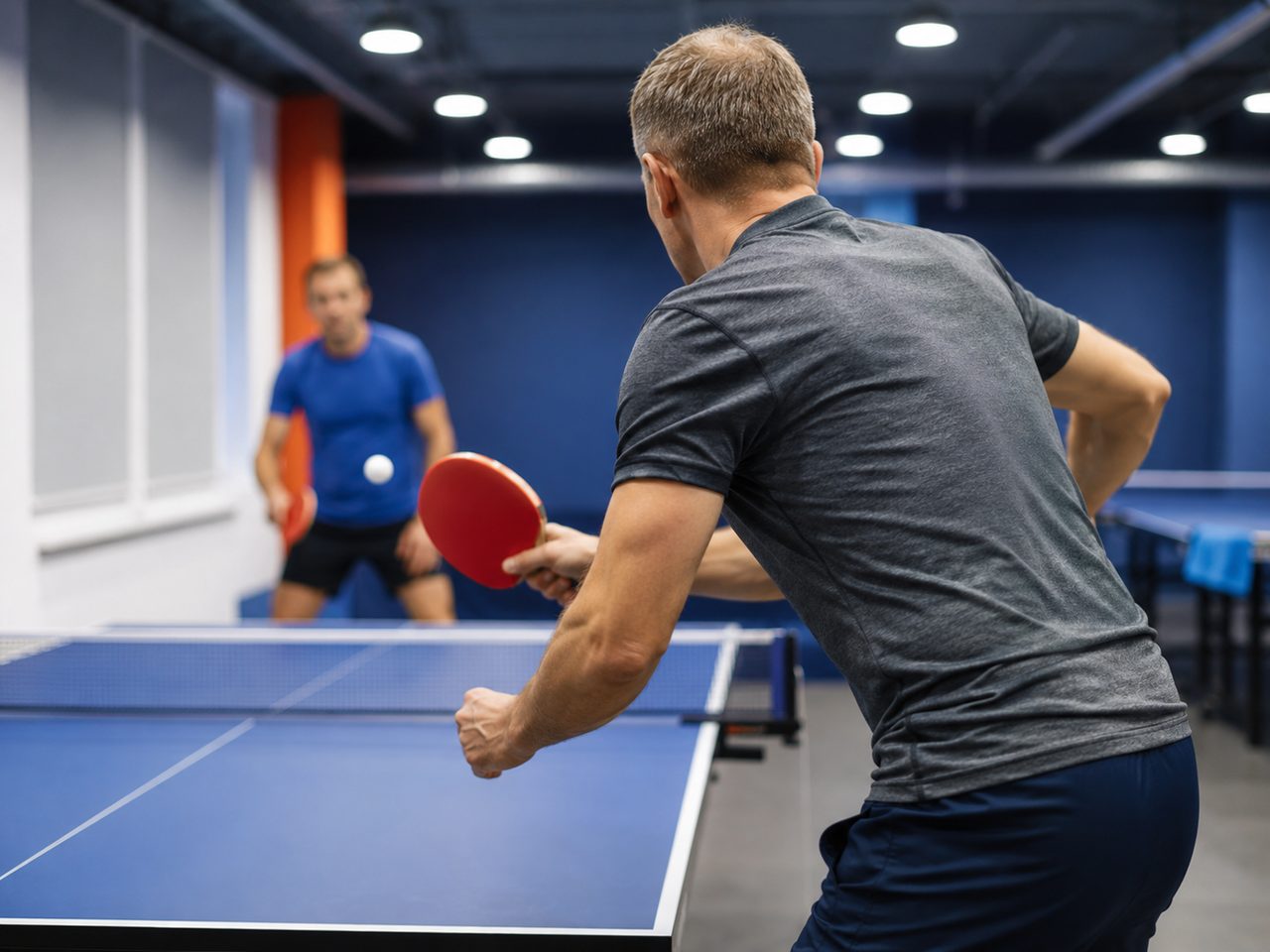 Adultos a jogar ténis de mesa